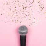 Mikrofon mit Sternenstaub auf rosa Hintergrund